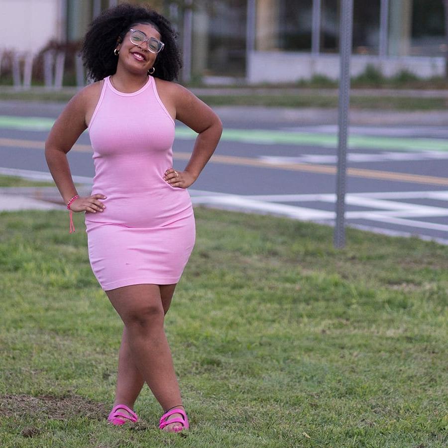 Student poses in pink dress at Campus Center.